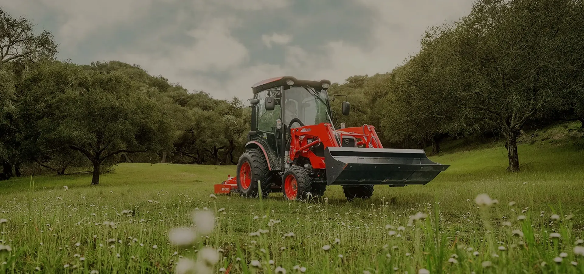 Tractor with a front loader working in a green field
